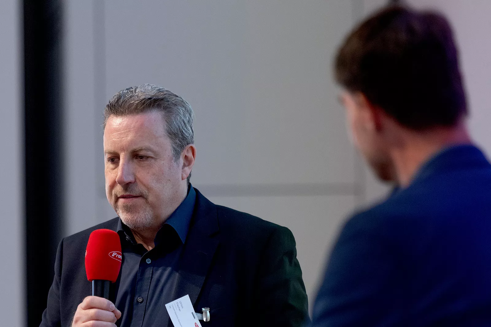 Mann moderiert mit einem Mikrofon