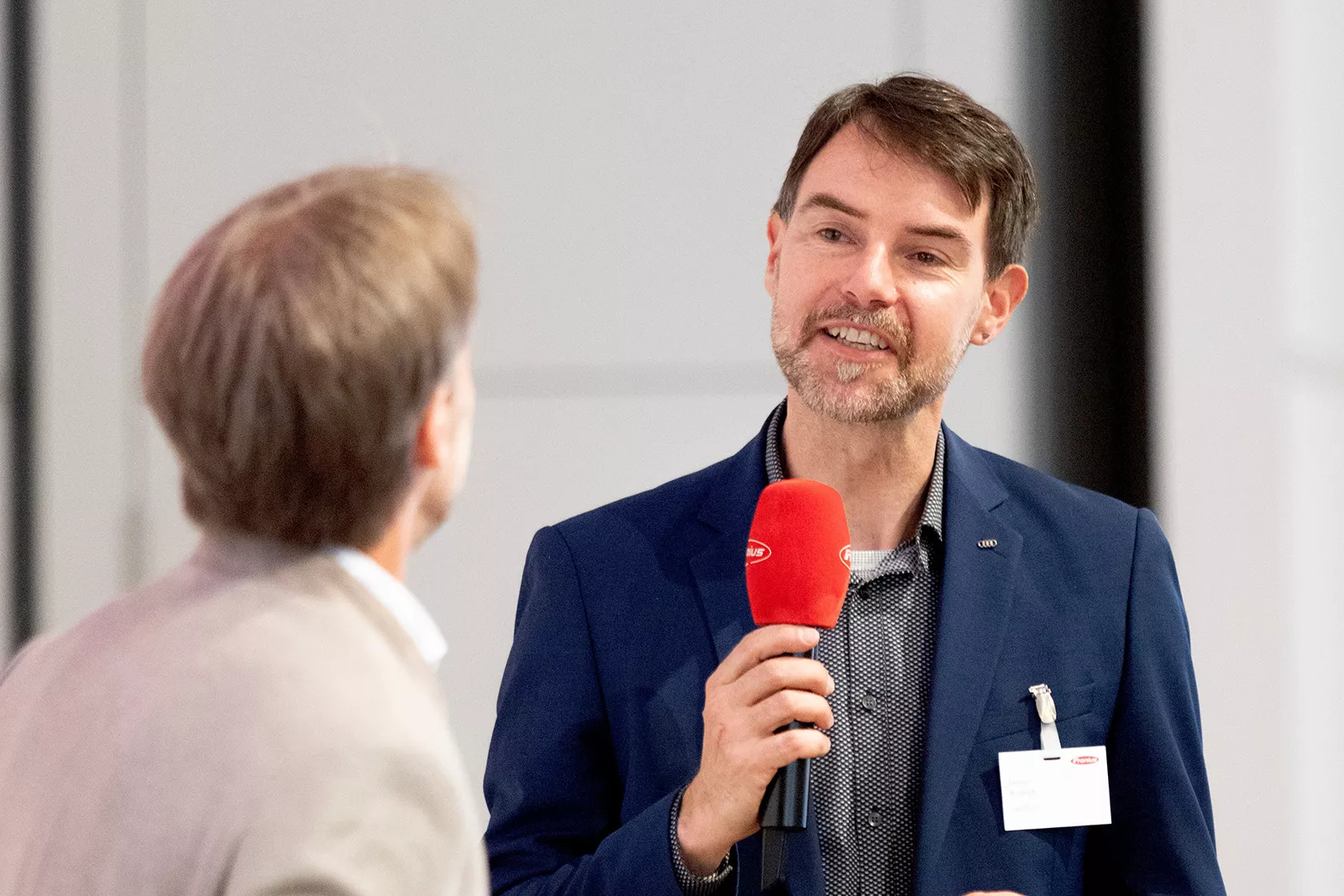 Mann moderiert mit einem Mikrofon